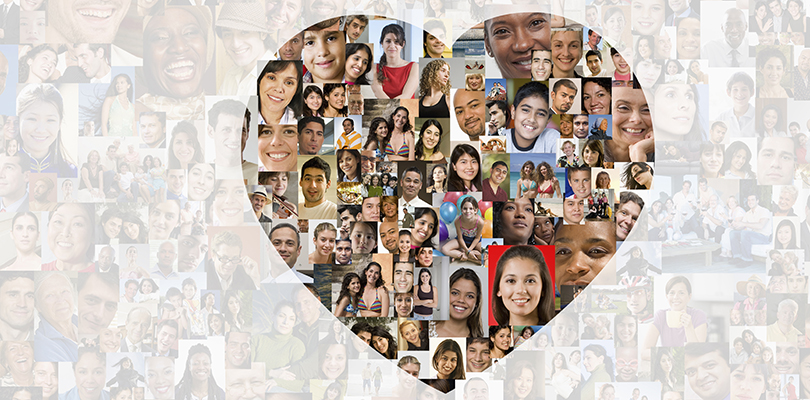 Illuminated heart in collage of smiling faces
