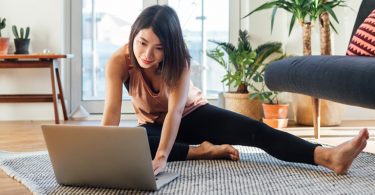 Woman on ground working on computer