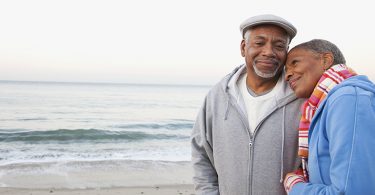 African American couple hugging on beach