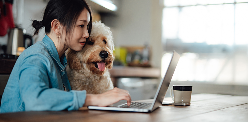 Young woman working from home with her dog