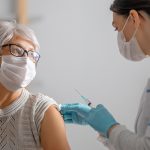 Doctor giving a senior woman a vaccination