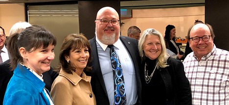 Retiring board member Rob Feckner (center) stands outside the recently named Feckner Auditorium with (from left) current team member SalliAnne Maliguine and former team members Mary Ann Burford, Esther Marcroft, and Ken Marzion.