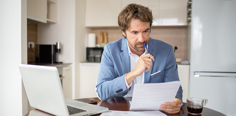 Man using calculator while going through bills and home finances
