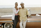 Black couple standing by convertible