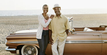 Black couple standing by convertible