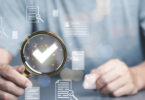 Man using a magnifying glass with a checkmark inside of it