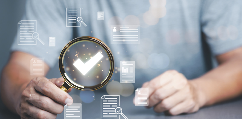 Man using a magnifying glass with a checkmark inside of it