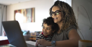 Mother and son using laptop computer together