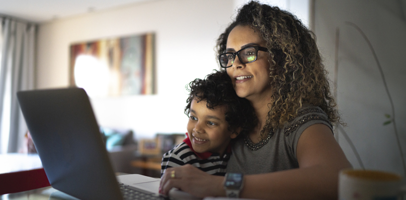 Mother and son using laptop computer together