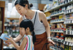 parent and child shopping together in a grocery store.