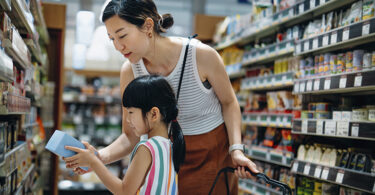 parent and child shopping together in a grocery store.