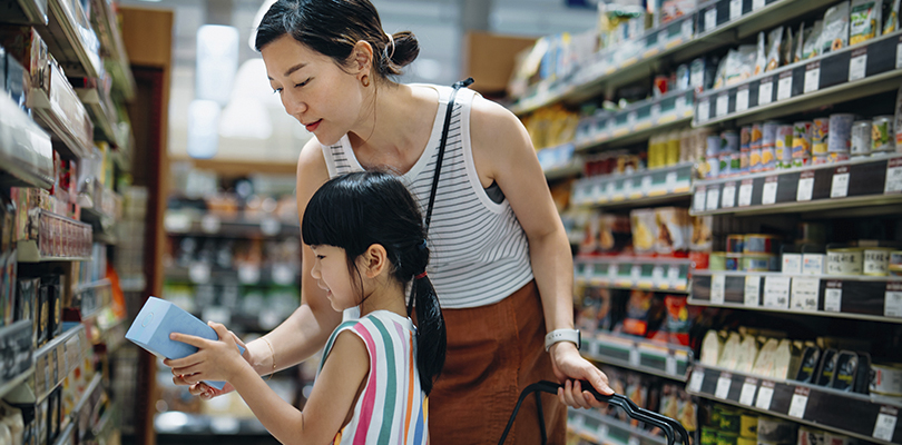 parent and child shopping together in a grocery store.