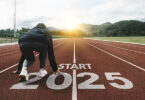 A runner about to run on an outdoor track with text underneath them that reads "Start 2025"