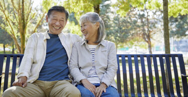 Older couple sitting together on bench