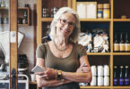 Senior woman holding pen and notepad in front of shelves of product