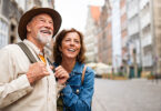 Happy senior couple tourists outdoors in historic town