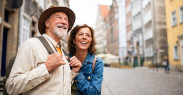 Happy senior couple tourists outdoors in historic town