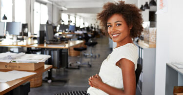 Woman sitting in office chair and smiling to camera