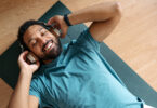 Man lying down on yoga mat with headphones on