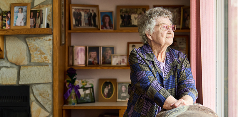 Elderly woman looking through a window