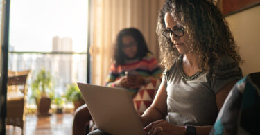 Woman wearing glasses using laptop.