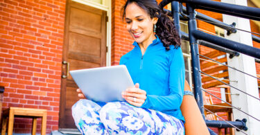 Woman sitting outside using tablet