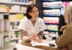 Pharmacist speaking to customer at checkout