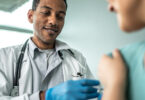 Doctor administering a vaccine to his patient