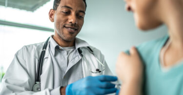 Doctor administering a vaccine to his patient