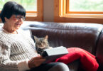 Senior woman using tablet with cat on her lap