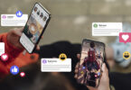 Two hands holding phones with general social media applications open, emojis decorating the foreground
