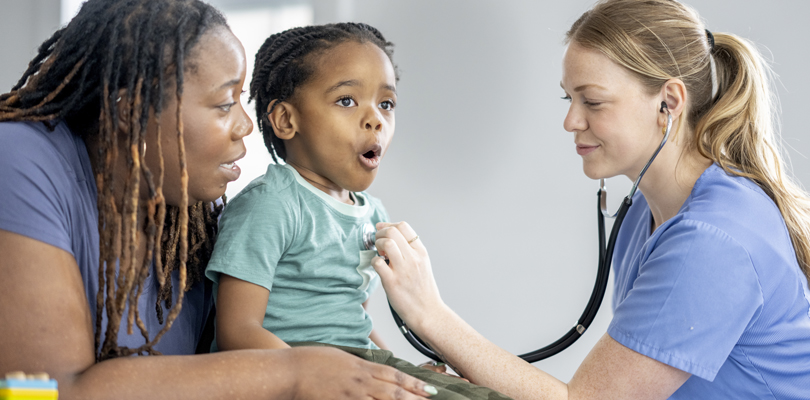Nurse using stethoscope on child